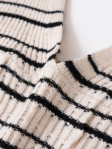 Detailaufnahme des V-Ausschnitt-Strickkleides mit cremefarbenen schwarzen Streifen