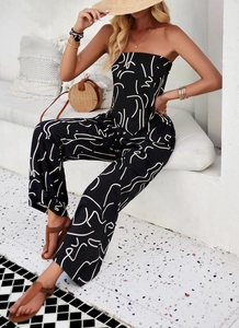 Detail of bohemian strapless jumpsuit with white abstract print on black fabric