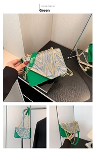 Detail view of green leather crossbody bag with marble texture flap and gold chain strap