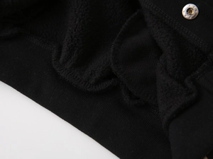 Close-up of thick black fleece lining and silver metal snap buttons on boy's jacket