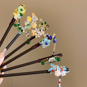 Detail of wooden hair sticks featuring alloy flowers, resin butterflies and beaded tassels
