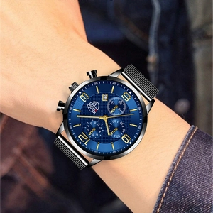 Close-up of blue textured dial with calendar and black metal mesh strap on men's quartz watch