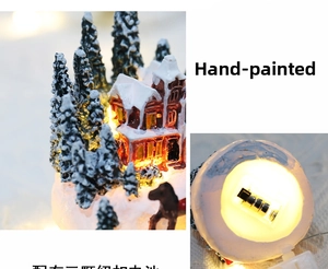 Detail view of hand-painted resin Christmas house with battery compartment and warm LED lights