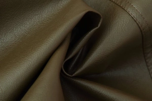 Detailed view of brown faux leather texture with precision stitching on a jacket