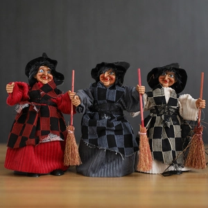 Three Halloween witch dolls with plaid dresses and brooms standing on a wooden surface
