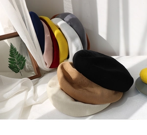 Stack of colorful knitted berets in multiple pastel colors with fine fabric texture
