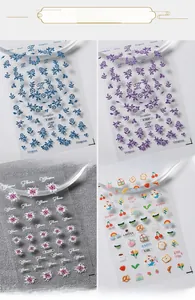 Detailed 3D embossed nail stickers featuring blue flowers, berries, and cartoon bear designs