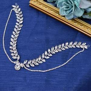 Close-up of silver leaf-shaped rhinestone bridal headpiece with elegant crystal pendant