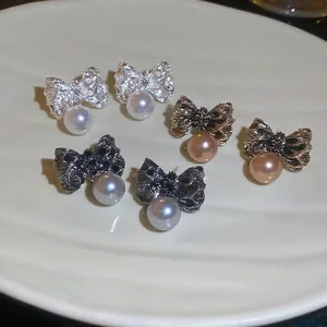 Boucles d'oreilles nœud et perle élégantes en argent, or et noir à texture plissée