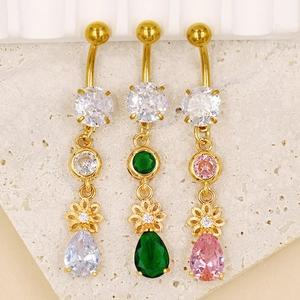 Gros plan de piercings de nombril fleur avec zircons roses et verts sur pierre