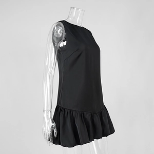Detail view of the black sleeveless mini dress featuring a ruffled bubble hem design