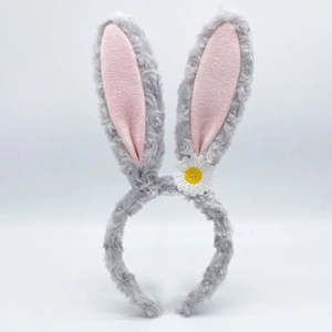 Detail view of plush rabbit ear headband in grey and pink with a daisy flower accent
