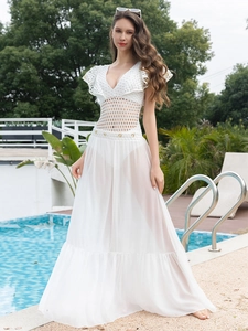 Detail of white crochet mesh swimsuit with deep V-neck and ruffled sleeves on beach resort