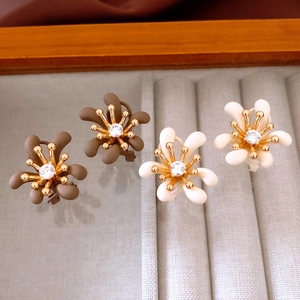 Dettaglio di fermagli per capelli a fiore opaco con cristallo centrale e oro