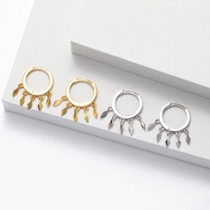Detail of silver and gold geometric rhomboid tassel earrings on white display stands