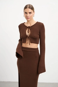 Détail de l'ensemble tricoté avec haut à lacets et jupe longue fendue sur le côté en marron