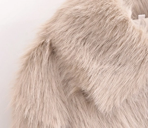 Close-up of soft beige faux fur collar texture on a cozy winter plush jacket