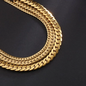 Elegant gold Cuban link chain bracelet made of stainless steel on a dark textured surface