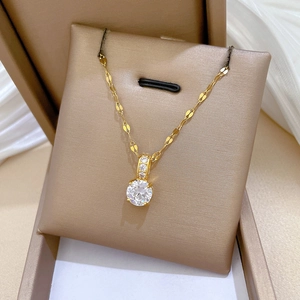 Details einer Goldkette aus Titan mit Zirkonia-Anhänger in einer Schmuckschatulle