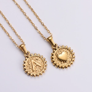 Macro detail of 18k gold plated stainless steel heart and letter pendant necklace