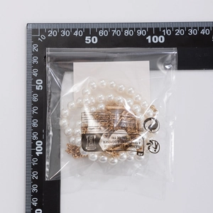 Detail view of multilayer shell and starfish necklace with scale ruler measurement