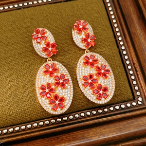 Detail of vintage flower earrings with red stones on a green velvet display