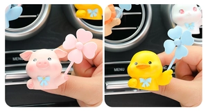 Detailed view of cute resin pig and duck air vent clips with clover pinwheels for cars