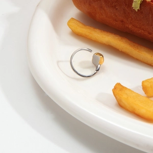 Détail de la bague croissant bicolore avec finition dorée et anneau ouvert en argent sur plat