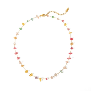 Macro detail of gold chain necklace with colorful irregular stones and lobster clasp
