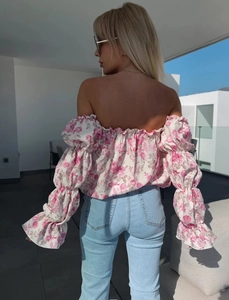 Vista posteriore di un top floreale rosa con spalle scoperte e maniche a palloncino