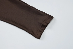 Gros plan sur la texture en maille fine et les coutures précises d'une manche marron