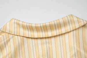 Détail du col à rayures jaunes et blanches en satin soyeux avec des coutures de haute qualité