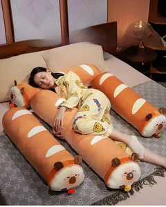 Scène de chambre avec un mannequin tenant un long oreiller en peluche Capybara baguette