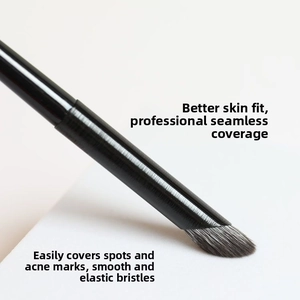 Vue macro d'un pinceau correcteur professionnel biseauté aux poils denses noirs et blancs