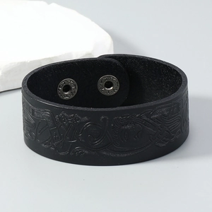 Macro shot of a black leather bracelet featuring embossed Celtic knots and snap buttons