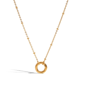 Detail view of a gold stainless steel necklace featuring a round clasp and pearl accents