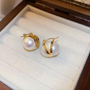 Detailed macro view of French vintage pearl earrings with gold hoop in a jewelry box