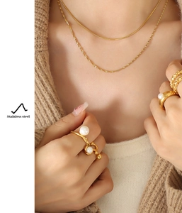 Detail showing the layered gold stainless steel snake chain and twist necklace set on model
