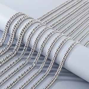 Polished stainless steel Cuban link chains in various sizes displayed on a grey stand