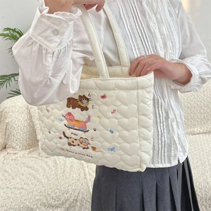 Quilted heart-patterned tote bag with cute animal embroidery shown on shoulder