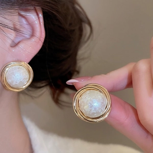 Elegant gold geometric earrings with textured pearl center for a luxury aesthetic