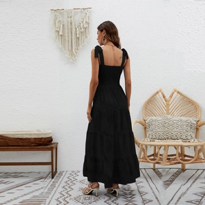 Λεπτομέρεια από τα κορδόνια και τα βολάν στην πλάτη ενός μαύρου μάξι φορέματος
