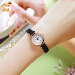 Elegant women's watch with rose gold case, white dial and black leather strap on wrist
