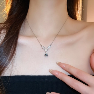 Dettaglio ravvicinato della collana con gemma quadrata blu scintillante su una modella