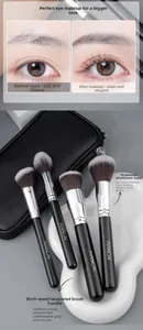 Detail view of four professional makeup brushes with silver ferrules and black birch handles