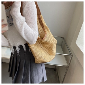 Mirror selfie showing the large woven straw tote bag with brown leather trim and strap