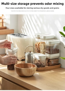 Set of four clear food storage canisters with white airtight lids on a kitchen counter