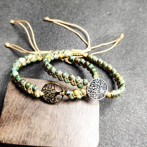 Detail of handmade African turquoise beaded bracelets featuring a metal tree of life charm