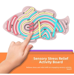 Detail of fish-shaped sensory activity board with colorful silicone strings for tactile play