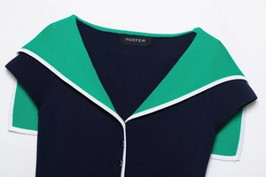 Close-up of navy blue and green knit top featuring contrasting lapel and white piping
